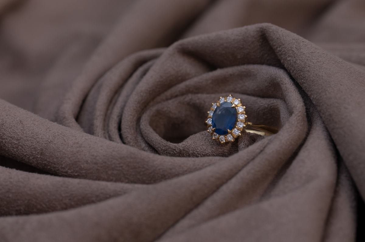 Gold ring set with a blue sapphire surrounded by diamonds