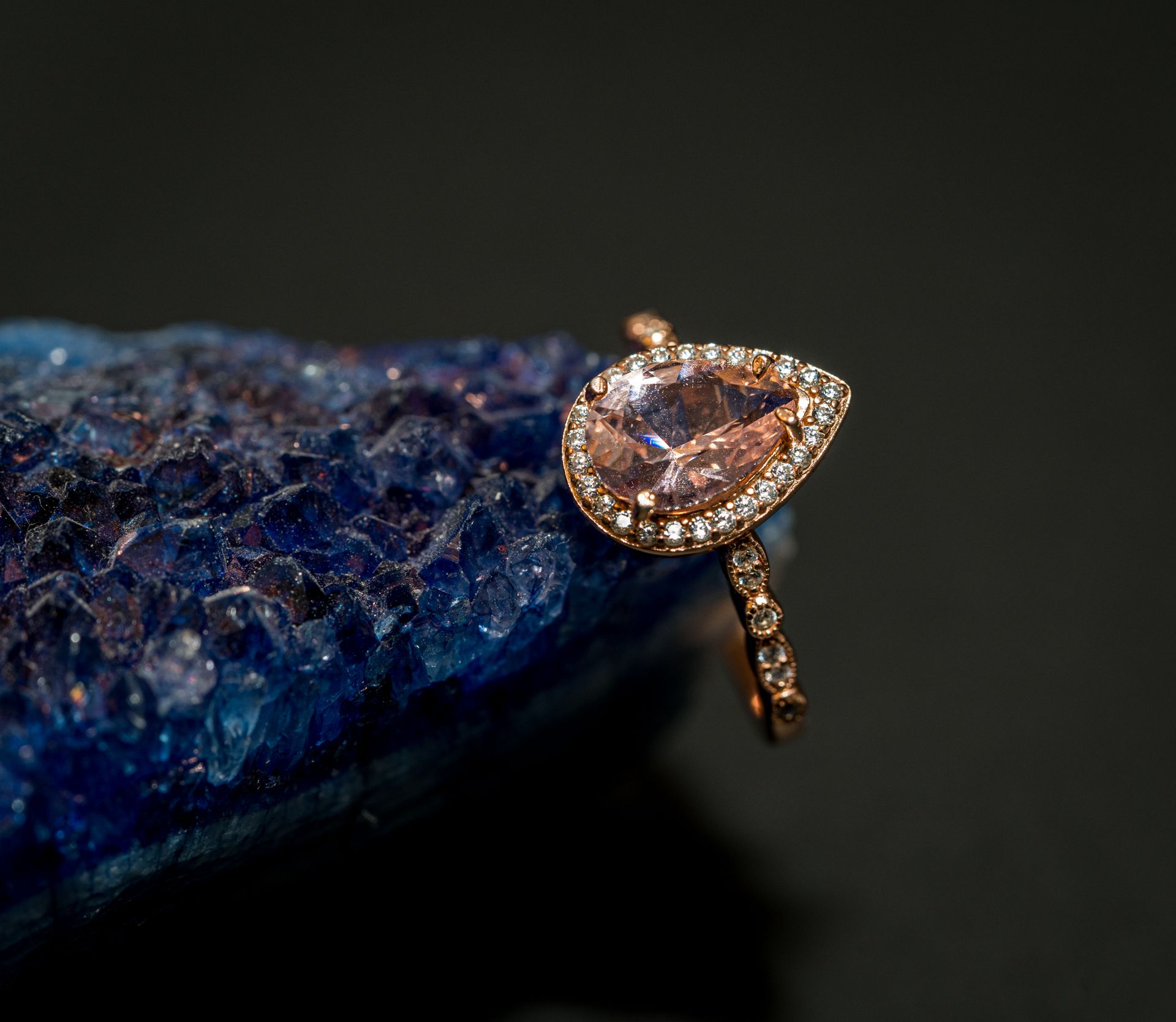 Gemstone ring resting on a deep blue sparkling surface